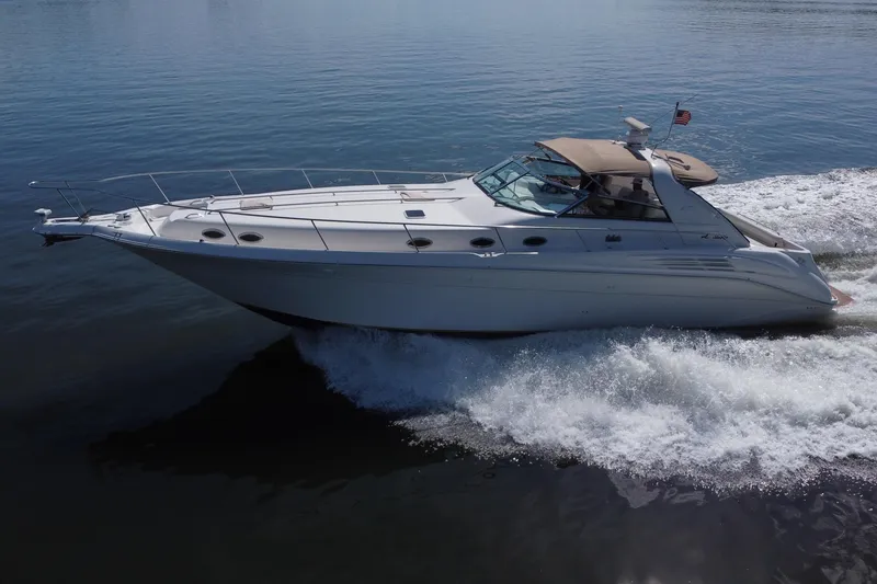 Slide: The Image of 1997 Sea Ray 450 Sundancer cruising on calm waters, showcasing sleek design and performance. - 14