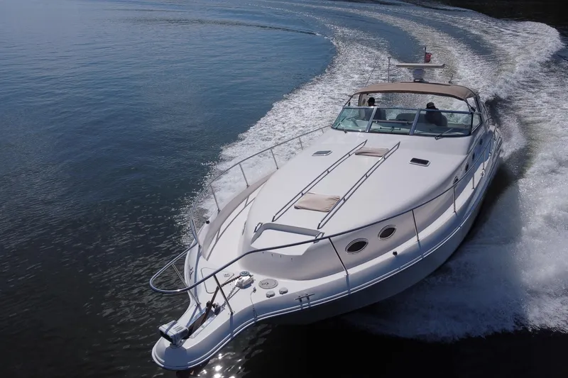 Slide: The Image of 1997 Sea Ray 450 Sundancer cruising on open water, creating a dynamic wake. - 3