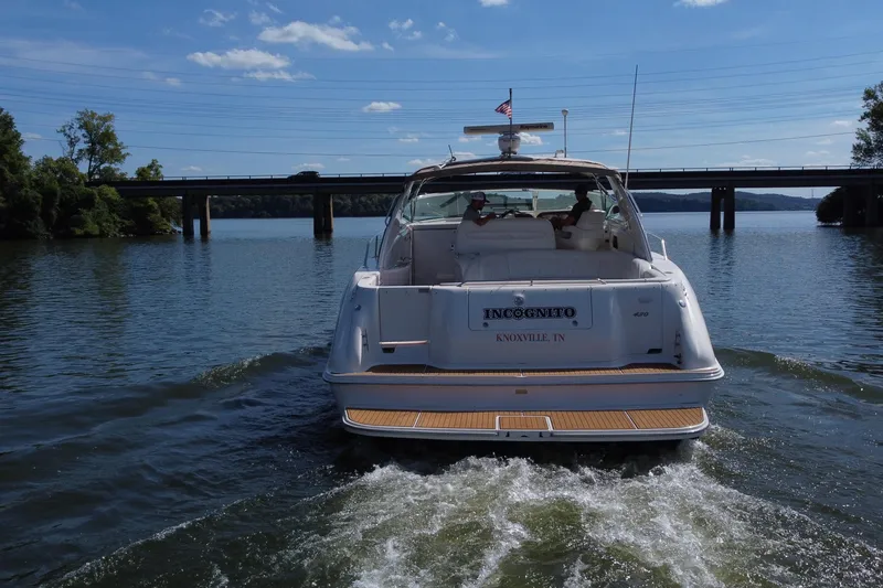 Slide: The Image of 1997 Sea Ray 450 Sundancer yacht cruising on a scenic lake near a bridge. - 8