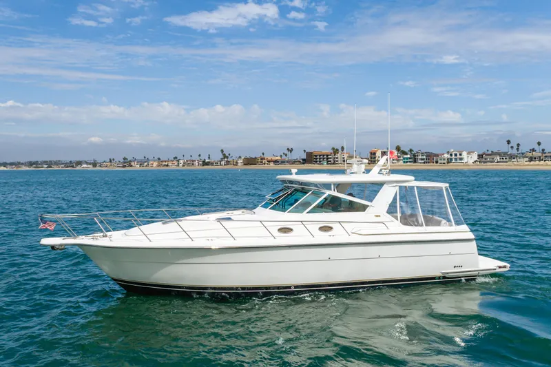 Slide: The Image of 2004 Tiara Yachts 4000 Express cruising on blue ocean near coastal homes. - 0