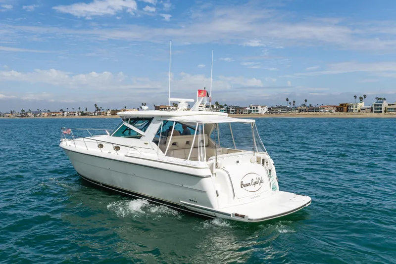 Slide: The Image of 2004 Tiara Yachts 4000 Express cruising on blue ocean near coastal homes. - 1