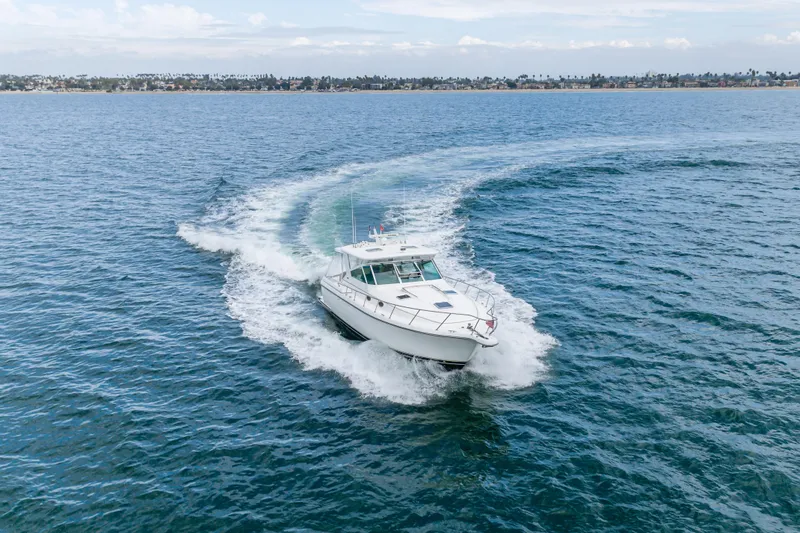 Slide: The Image of 2004 Tiara Yachts 4000 Express cruising on open water, creating a dynamic wake. - 13