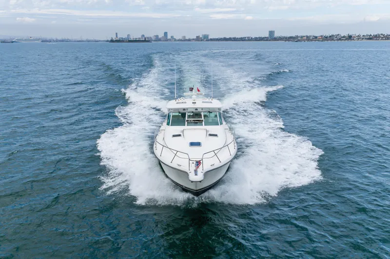 Slide: The Image of 2004 Tiara Yachts 4000 Express cruising on open water with city skyline in background. - 15