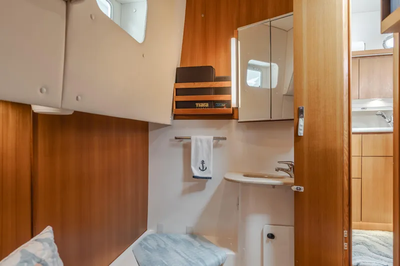 Slide: The Image of 2004 Tiara Yachts 4000 Express interior with wooden cabinetry and compact bathroom. - 29