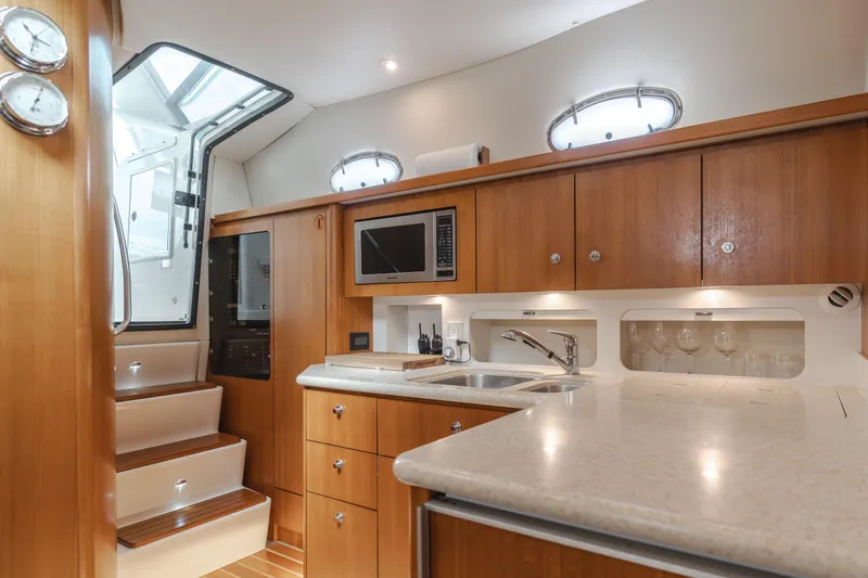 Slide: The Image of 2004 Tiara Yachts 4000 Express interior with modern kitchen, wood cabinetry, and stainless steel fixtures. - 40