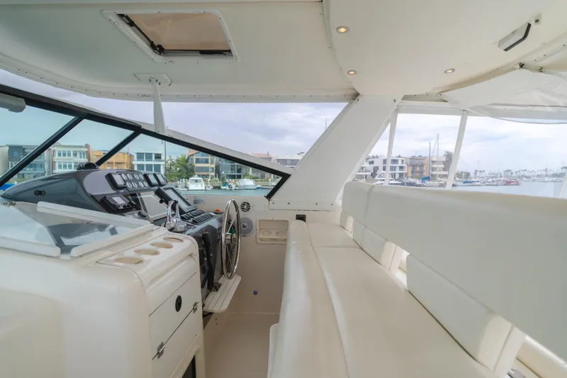 Slide: The Image of 2004 Tiara Yachts 4000 Express interior with helm and seating, overlooking marina. - 48