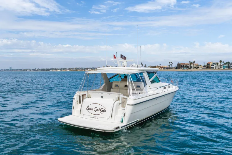 Slide: The Image of 2004 Tiara Yachts 4000 Express on water near coastal buildings under blue sky. - 5