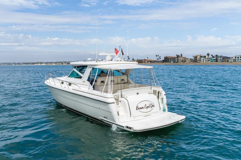 Slide: The Image of 2004 Tiara Yachts 4000 Express cruising on calm waters near a coastal town. - 7