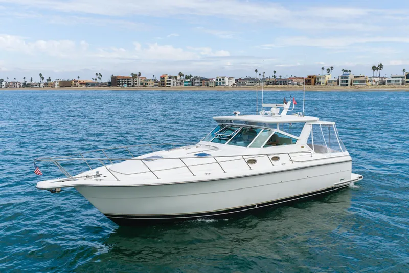 Slide: The Image of 2004 Tiara Yachts 4000 Express cruising on calm blue waters near coastal homes. - 8