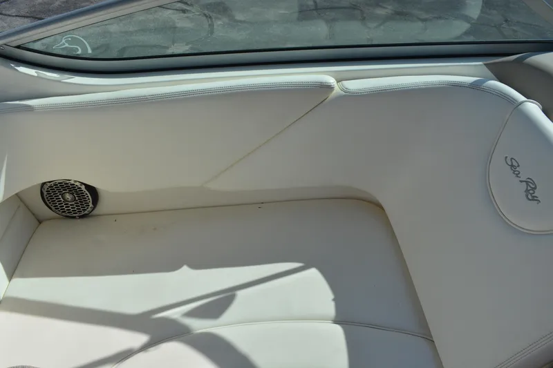 Slide: The Image of 2005 Sea Ray 280 Sundancer interior with white seating and speaker detail. - 10