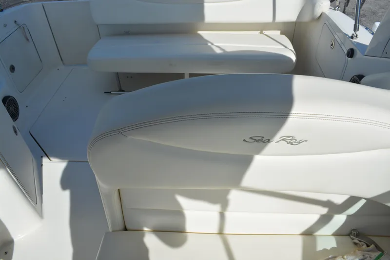 Slide: The Image of 2005 Sea Ray 280 Sundancer boat interior with white seating and logo. - 11