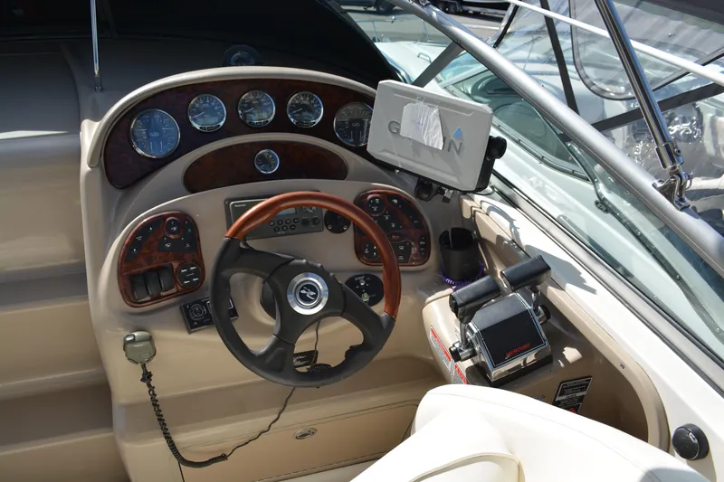 Slide: The Image of 2005 Sea Ray 280 Sundancer helm with gauges, steering wheel, and navigation equipment. - 12
