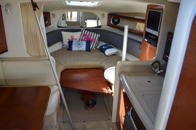 Slide: The Image of Interior of 2005 Sea Ray 280 Sundancer with cozy seating and nautical decor. - 13