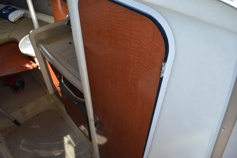 Slide: The Image of 2005 Sea Ray 280 Sundancer cabin interior with wooden door and seating area. - 15