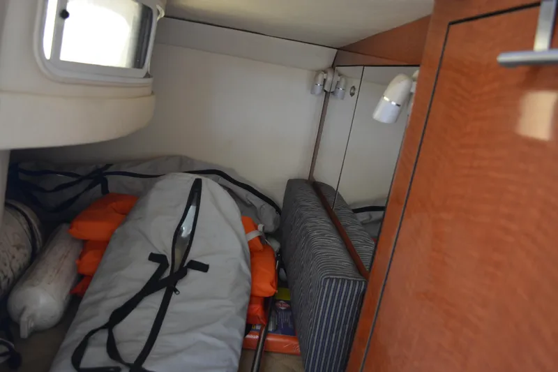 Slide: The Image of 2005 Sea Ray 280 Sundancer cabin storage with life jackets and equipment. - 16