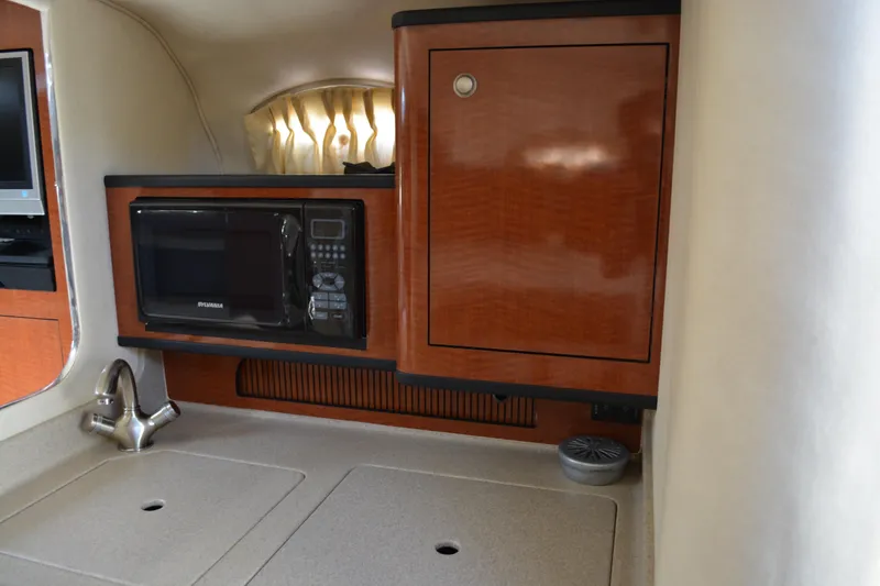 Slide: The Image of 2005 Sea Ray 280 Sundancer interior with microwave and wooden cabinetry. - 18