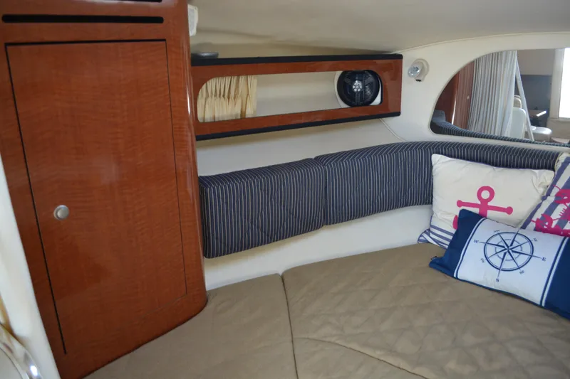 Slide: The Image of Interior of 2005 Sea Ray 280 Sundancer with nautical-themed cushions and wood cabinetry. - 19