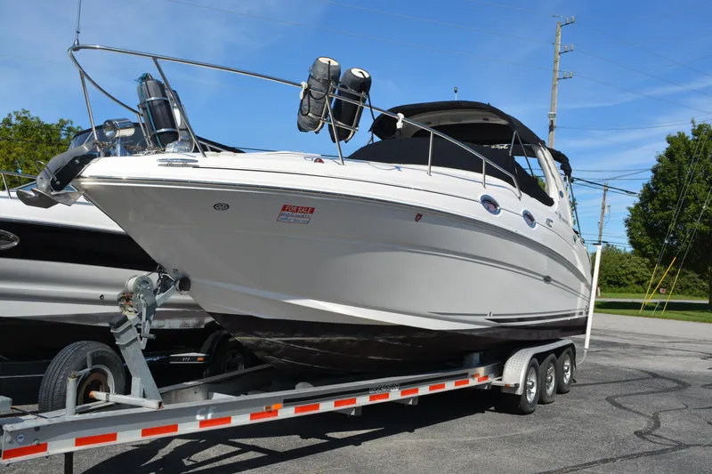 Slide: The Image of 2005 Sea Ray 280 Sundancer boat on trailer, for sale, under clear blue sky. - 2