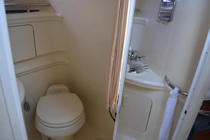 Slide: The Image of 2005 Sea Ray 280 Sundancer bathroom with toilet, sink, and mirror. - 21
