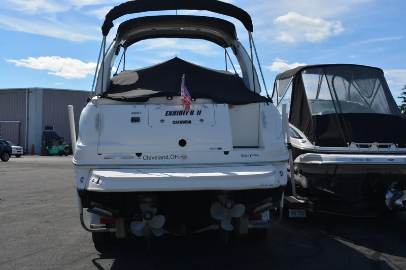 Slide: The Image of 2005 Sea Ray 280 Sundancer boat docked, rear view, with cover and American flag. - 5