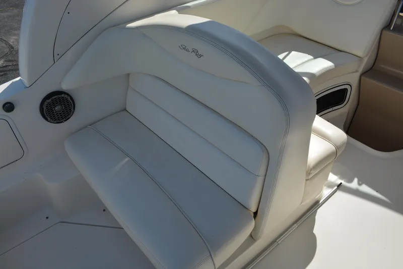 Slide: The Image of 2005 Sea Ray 280 Sundancer interior seating with white upholstery and speaker. - 7