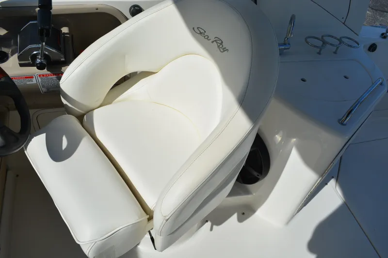Slide: The Image of Captain's seat on a 2005 Sea Ray 280 Sundancer boat, featuring white upholstery. - 9