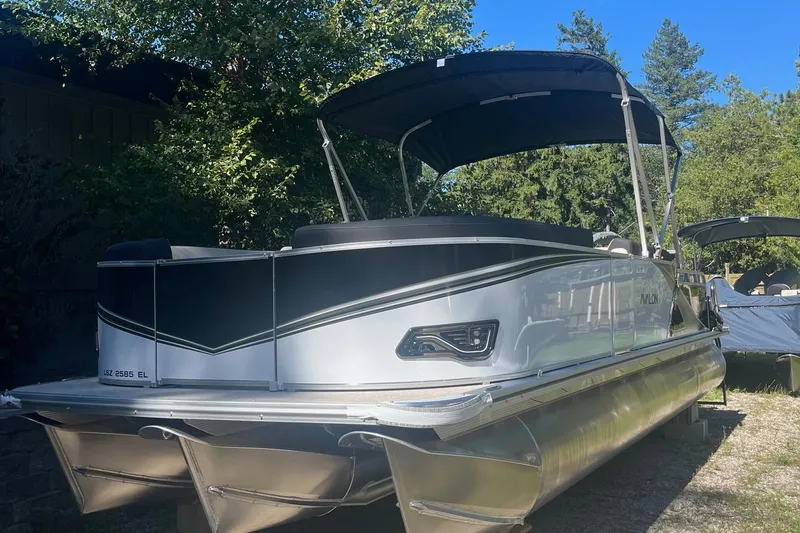 The Image of 2026 Avalon 23 LSZ Elite pontoon boat with sleek design, parked outdoors. - 1