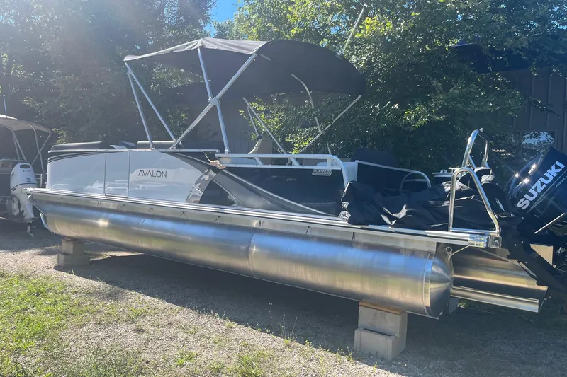 Slide: The Image of 2026 Avalon 23 LSZ Elite pontoon boat with Suzuki outboard motor, parked outdoors. - 7