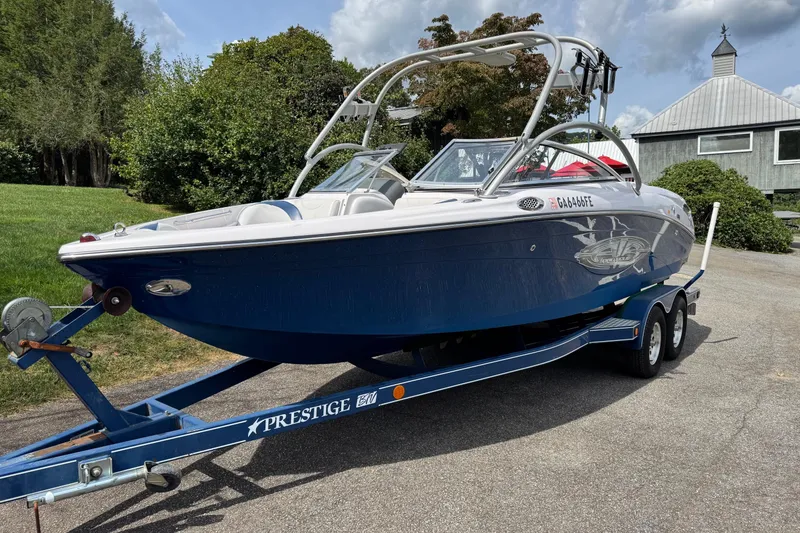 Slide: The Image of 2004 Correct Craft Air Nautique 226 boat on trailer, parked outdoors. - 2