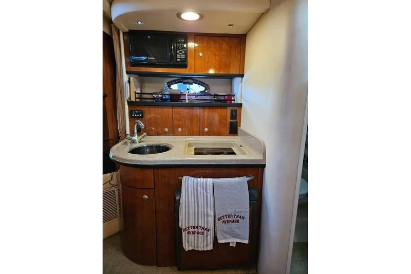 Slide: The Image of 2006 Sea Ray 290 Sundancer boat kitchenette with sink, stove, and microwave. - 10