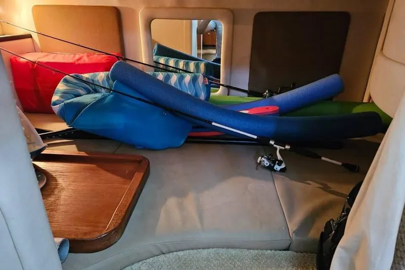 Slide: The Image of Interior of 2006 Sea Ray 290 Sundancer with fishing rods and pool noodles. - 13