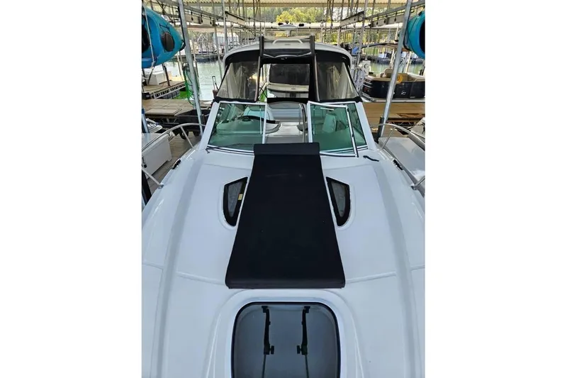 Slide: The Image of 2006 Sea Ray 290 Sundancer boat docked, featuring sleek white deck and black sunpad. - 16