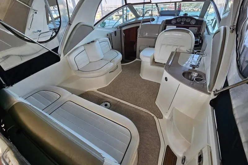 Slide: The Image of 2006 Sea Ray 290 Sundancer interior with seating, helm, and kitchenette. - 5
