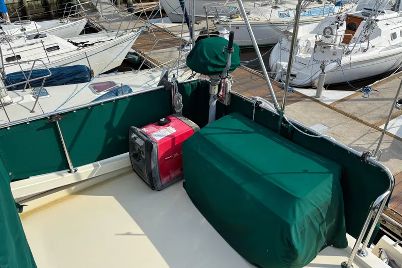 Slide: The Image of 2004 Camano Trawler deck with green covers and a red generator. - 12