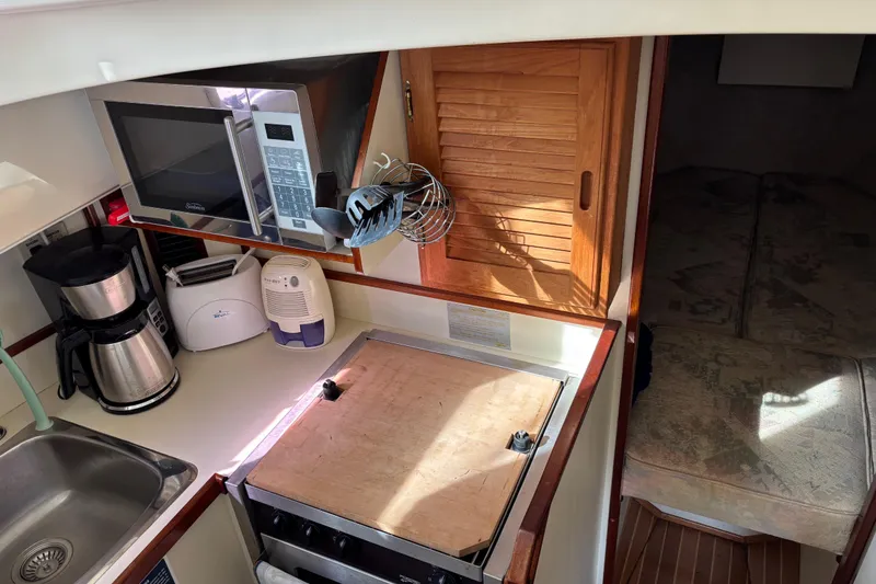 Slide: The Image of 2004 Camano Trawler kitchen with microwave, coffee maker, and stove. - 14