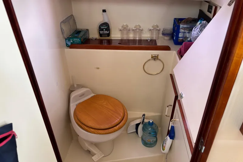 Slide: The Image of 2004 Camano Trawler bathroom with wooden toilet seat and cleaning supplies. - 18