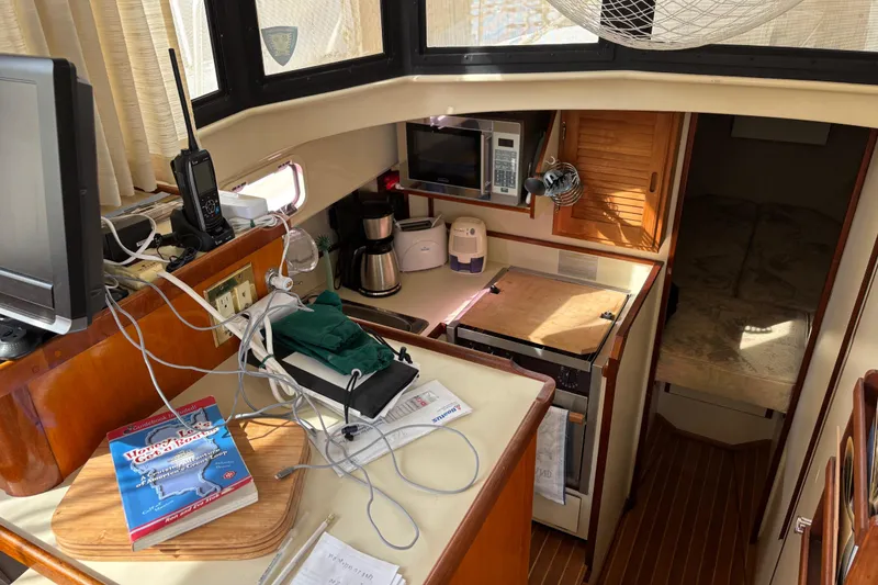 Slide: The Image of 2004 Camano Trawler interior with kitchen, electronics, and cozy sleeping area. - 20