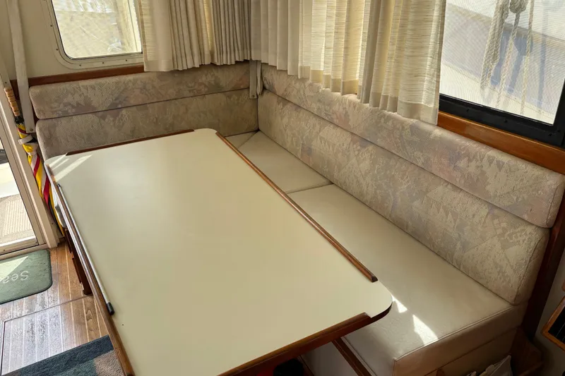 Slide: The Image of 2004 Camano Trawler interior with dining table and cushioned seating. - 22