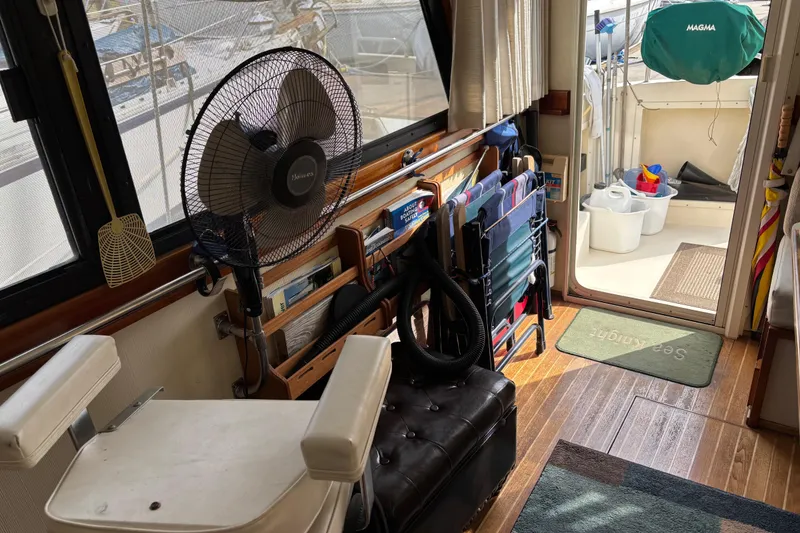 Slide: The Image of 2004 Camano Trawler interior with fan, chairs, and nautical equipment. - 23