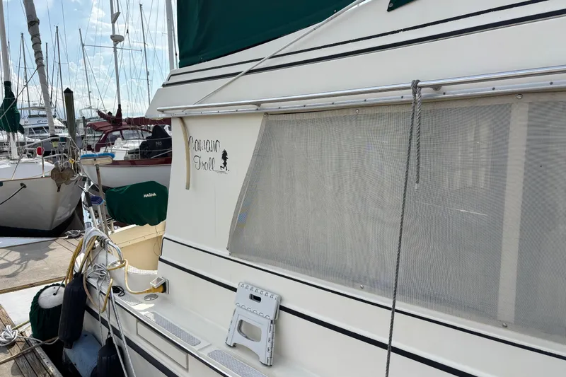 Slide: The Image of 2004 Camano Trawler docked at marina, featuring side view and nautical equipment. - 3