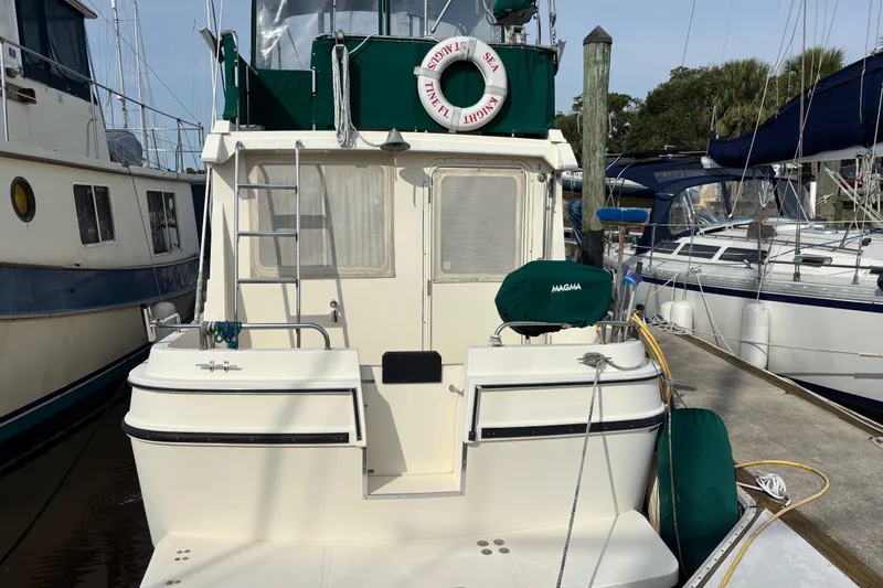 Slide: The Image of 2004 Camano Trawler docked, featuring green accents and a life preserver. - 4