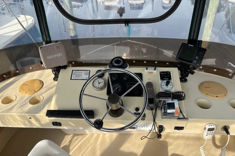 Slide: The Image of 2004 Camano Trawler helm with steering wheel, navigation instruments, and Garmin GPS system. - 8