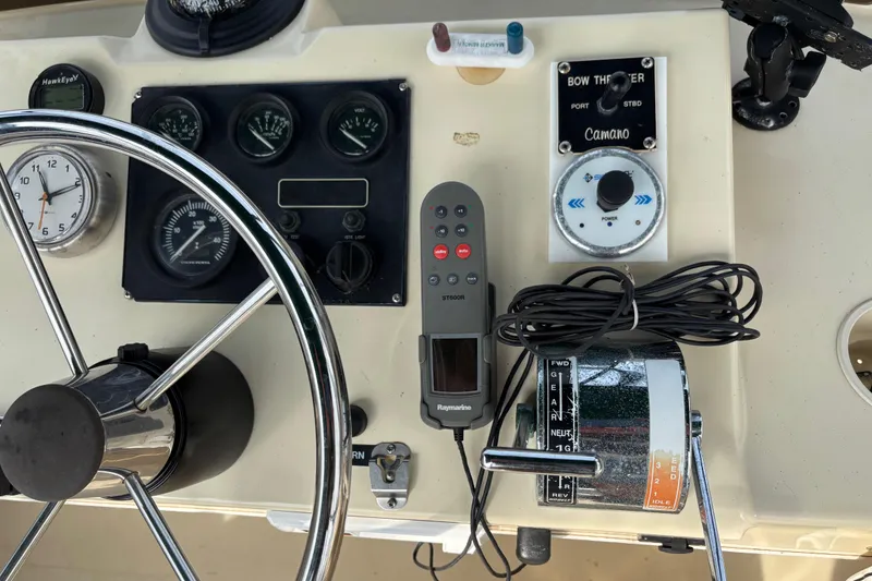Slide: The Image of 2004 Camano Trawler helm with steering wheel, gauges, and navigation controls. - 9