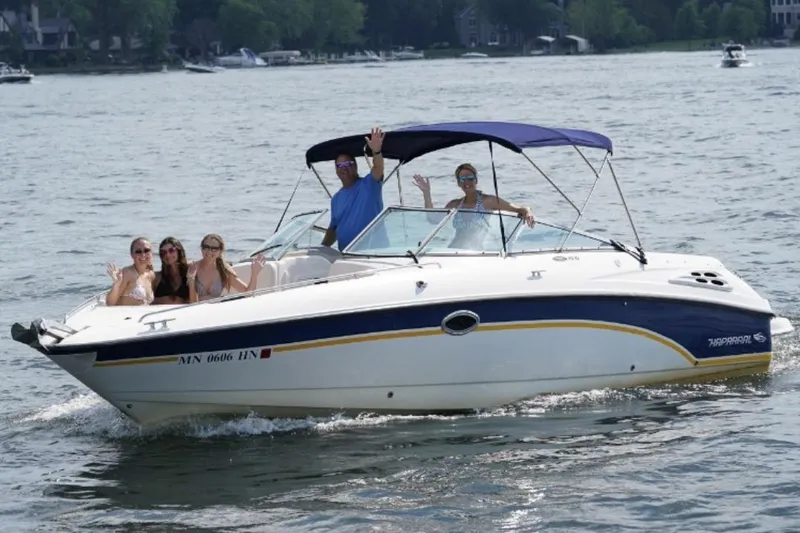 Slide: The Image of 1999 Chaparral 2830 SS boat with passengers waving on a sunny lake. - 1