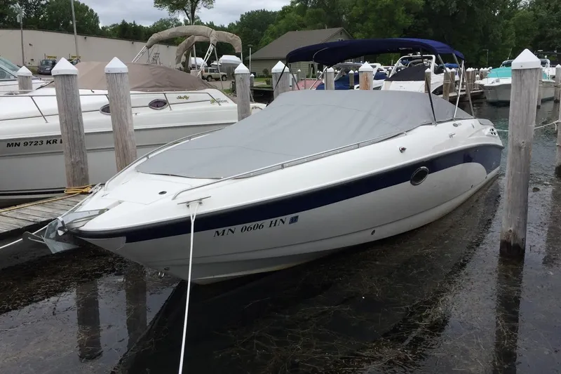 Slide: The Image of 1999 Chaparral 2830 SS boat docked, covered, with blue and white design. - 3
