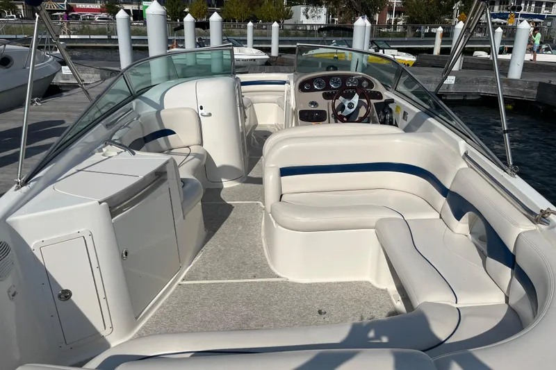 Slide: The Image of 1999 Chaparral 2830 SS boat interior with seating and steering wheel, docked at marina. - 5