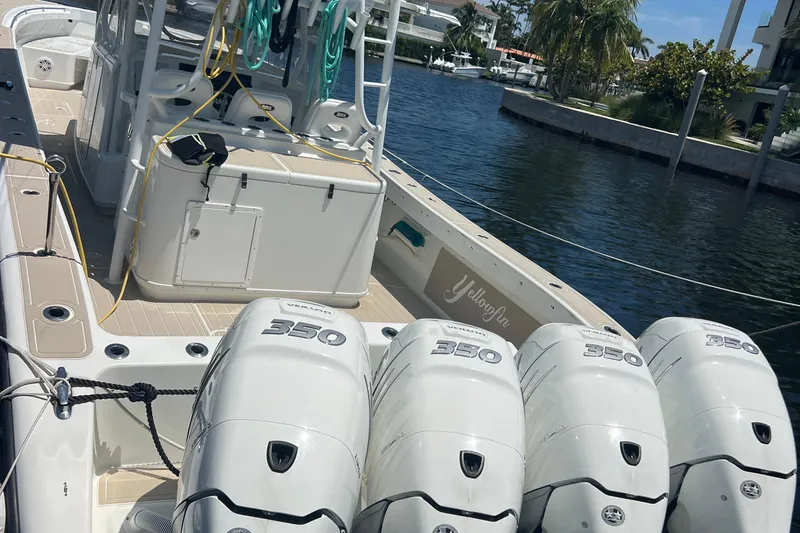 Slide: The Image of 2011 Yellowfin 42 Offshore boat with four powerful outboard engines docked by the water. - 11