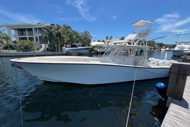 Slide: The Image of 2011 Yellowfin 42 boat docked in a marina, clear blue sky background. - 2