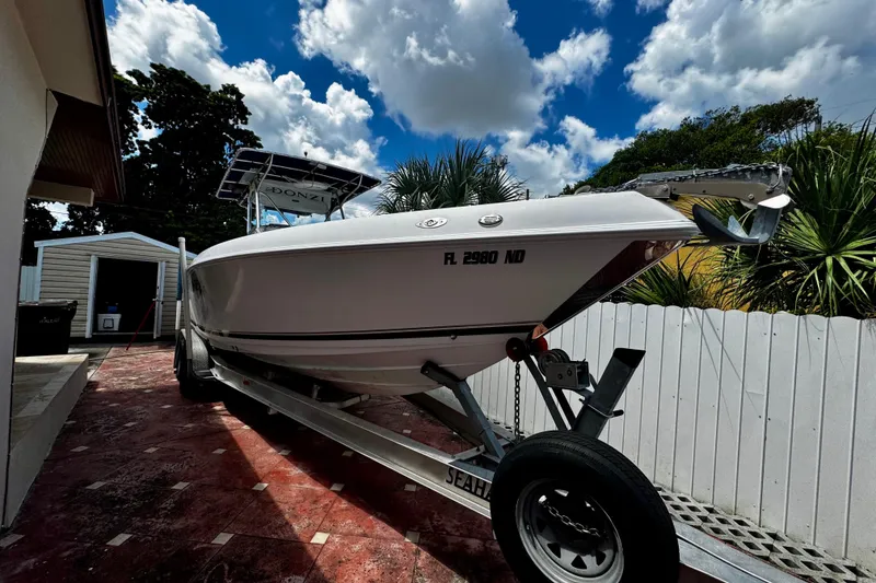 The Image of 2006 Donzi 32 ZF boat on trailer, parked outdoors under a partly cloudy sky. - 0
