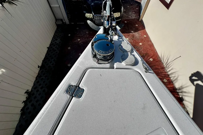 Slide: The Image of 2006 Donzi 32 ZF boat deck with anchor and winch, parked near a car. - 24